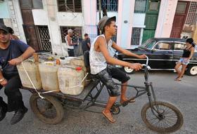 Dos hombres transportan agua en un triciclo en La Habana, en esta foto de archivo de 2011
