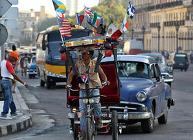 Un bicitaxi adornado con varias banderas, entre ellas una de Estados Unidos, circula por una calle de La Habana el 31 de marzo de 2015