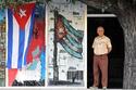 Un vigilante permanece junto a la entrada de un edificio adornada con banderas de Cuba, el sábado 24 de diciembre de 2011, en La Habana. EFE