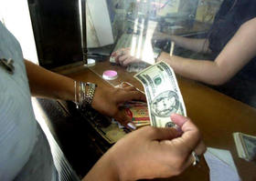 Una mujer cambia dólares por pesos convertibles cubanos en una entidad gubernamental. La Habana, 26 de octubre de 2004. (GETTY IMAGES)