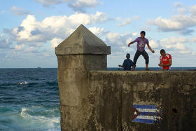 Niños cubanos pescando en el malecón habanero