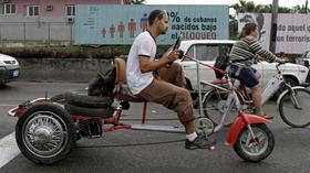 Cubanos en bicicleta en una calle de La Habana