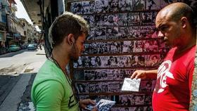 Un hombre compra un CD a un cuentapropista o trabajador del sector privado, en La Habana