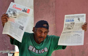 Un vendedor muestra los diarios oficiales Granma y Juventud Rebelde el miércoles 15 de abril de 2015, en una calle de La Habana