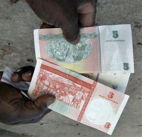 Un cubano muestra billetes de pesos convertibles, que se pueden comprar en las casas de cambio