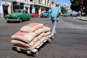 Un trabajador arrastra una carretilla con sacos de cemento en La Habana, Cuba