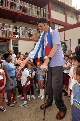 El turco Sultán Kosen, que con sus 2,47 metros es el hombre más alto del mundo, saluda a niños de una escuela en La Habana, el lunes 14 de marzo de 2011