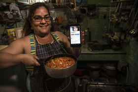 Yuliet Colón posa para una foto sosteniendo su teléfono celular y una olla de su creación, «Pisto manchego estilo cubano»