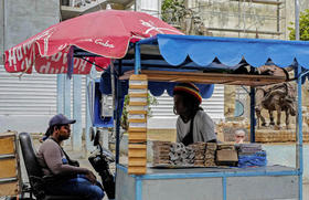 Dueños de puestos callejeros esperan por clientes en una calle de La Habana, el 31 de marzo de 2023