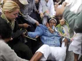Agentes de la Seguridad del Estado cubana arrastran por las calles a las Damas de Blanco.