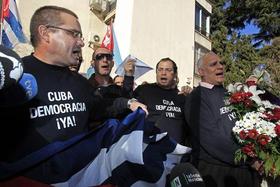 El presidente de la Plataforma Cuba Democracia ¡Ya!, Yuniel Jacobino (i), y el portavoz, Rigoberto Carceller (d), entre otros, durante la concentración ante la embajada de Cuba por la muerte del disidente cubano Wilman Villar