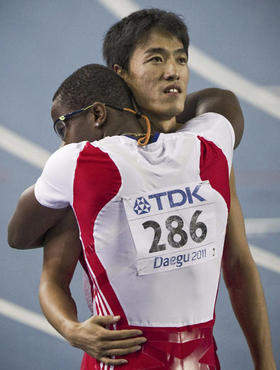 El cubano Dayron Robles (i), que se abraza al chino Xiang Liu (d), fue descalificado tras ganar la final de los 110 metros vallas de los Mundiales de Atletismo en Daegu