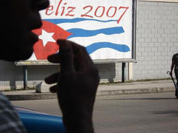 Silueta de un habanero frente a un cartel gubernamental Silueta de un habanero frente a un cartel gubernamental