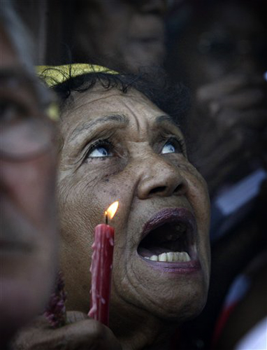 Una mujer ruega a Santa Bárbara durante una procesión en su honor