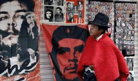 Un hombre camina junto a carteles, insignias e imágenes en general de Ernesto Che Guevara, antes de la celebración de un acto para comemorar la presidencia de Rafael Correa en Ecuador, en esta foto de archivo de enero de 2010