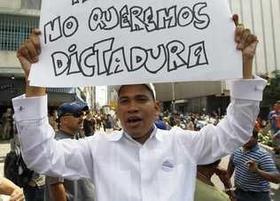 Un manifestante eleva un cartel en una protesta contra las últimas medidas del gobierno venezolano