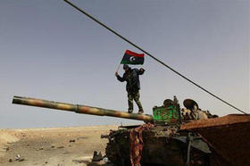 Un rebelde libio subido a un tanque en la carretera entre Ajdabiya y Brega el 6 de abril de 2011