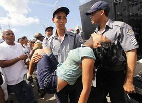 Un policía traslada a una mujer que sufre un desmayo