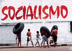 Un grupo de personas camina junto a un muro donde aparece la palabra Socialismo