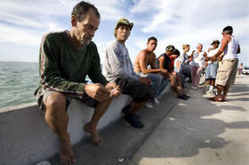 Parte de un grupo de inmigantes cubanos sentados en el malecón cerca del aeropuerto de Cayo Hueso, luego de su llegada a la Florida, el 23 de febrero de 2008