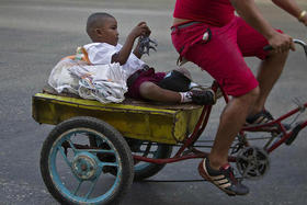 Niño cubano transportado en una bicicleta en Cuba