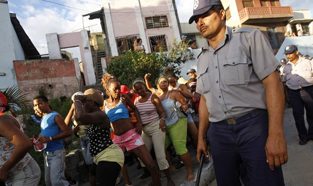 Una conga en Santiago de Cuba, vigilada de cerca por la Policía. (REUTERS)