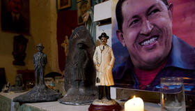 Fotografía del presidente venezolano Hugo Chávez, junto a una vela encendida y una imagen del beato Dr. José Gregorio Hernández