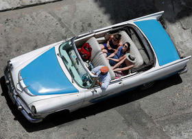 Turistas pasean en un viejo automóvil estadounidense en Cuba