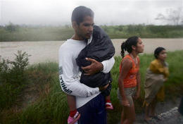 Residentes que esperaban por el transporte, bajo la lluvia del huracán Ike, en Herradura, Pinar del Rio. (AP)