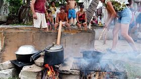 Cubanos cocinando con leña en la Isla