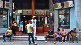 Cubanos aguardan para poder entrar a un cibercafé en La Habana