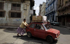 Una pareja empuja un automóvil en La Habana, en esta foto de archivo