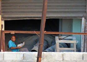 Un hombre lee un diario en una obra en construcción, el sábado 30 de julio de 2011, en La Habana, un día antes de cumplirse 5 años de la renuncia del líder cubano Fidel Castro y de que su hermano, el general Raúl Castro, asumiera el poder