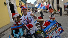 Un vendedor ambulante, anunciando sus productos con sus perros en La Habana, el 23 de diciembre de 2015