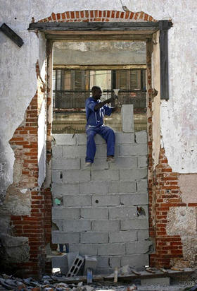 Un hombre desmonta ladrillos de un edificio abandonado, en La Habana. (REUTERS)