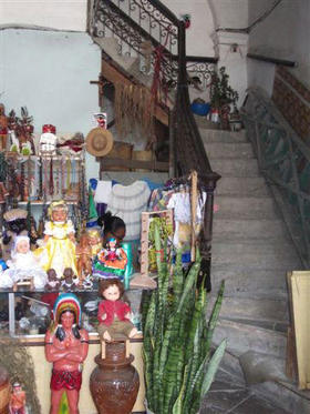 Puesto de venta de objetos de santería, a la entrada de la escalera de un edificio en La Habana