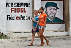 Dos jóvenes pasan frente a un cartel con la imagen de Fidel Castro, el 13 de agosto de 2017, en La Habana