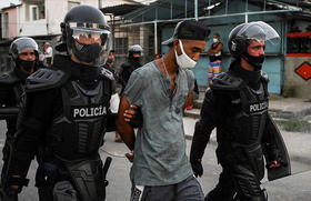 Dos policías llevan detenido a un hombre durante las protestas contra el régimen cubano en La Habana este lunes 12/07/2021