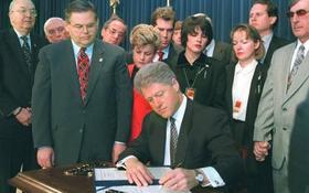 El entonces presidente estadounidense Bill Clinton firma la Ley Helms-Burton junto a los congresistas Ileana Ros-Lehtinen (traje rojo), Bob Menéndez (cerca de Clinton), Jesse Helms (más a la izquierda) y Lincoln Díaz-Balart