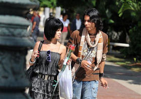 Una pareja de jóvenes cubanos camina por el Parque Central de La Habana