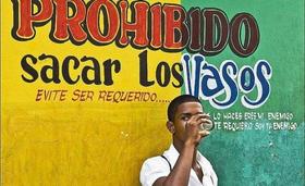 Joven tomando guarapo en Cuba