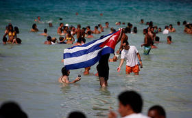 Un hombre ondea una bandera cubana en esta foto de archivo del festival anual Rotilla en la playa de Jibacoa, Cuba