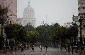 Niños jugando bajo la lluvia en La Habana