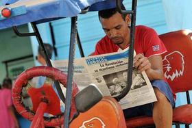 El conductor de un bicitaxi lee la prensa en La Habana (Cuba), un día después de la clausura del VI Congreso del Partido Comunista de Cuba (PCC), el miércoles 20 de abril de 2011