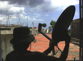 Un ciudadano orienta su antena parabólica en La Habana. (EL PAÍS)