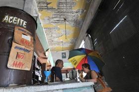 Una mujer comprando alimentos con la libreta de racionamiento en una bodega, 9 de junio de 2009, La Habana, Cuba