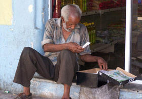 Un anciano vende artículos en un portal habanero