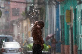 Un cubano se baña con el agua proveniente de una tubería en La Habana. Archivo