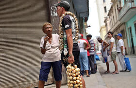Una mujer habla con un joven que vende ajos y cebollas en la calle, en esta fotografía de abril de 2016