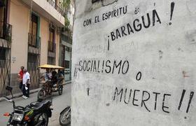 Varias personas pasan cerca a una pintada el jueves 13 de octubre de 2011, en La Habana